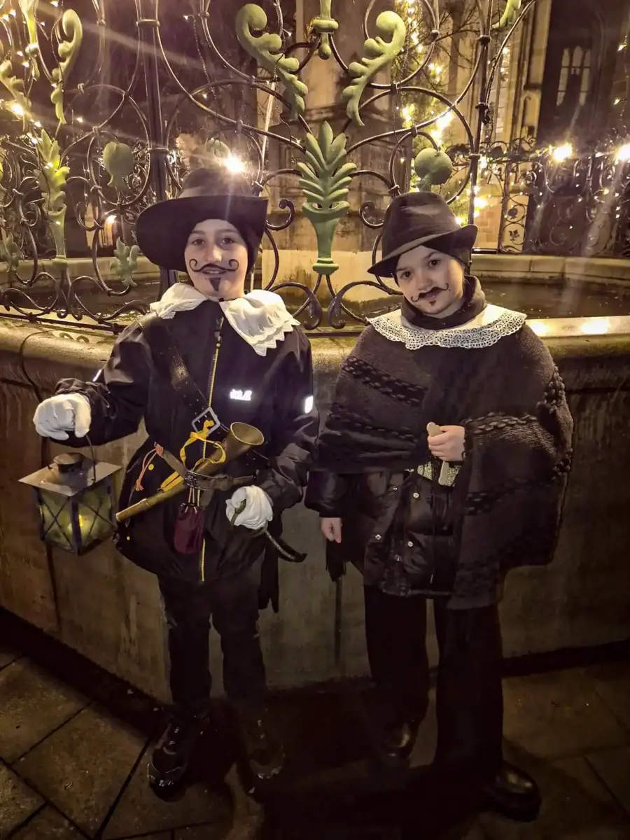 Kinder in historischen Kostümen ziehen als Hätscherklooßen durch die verschneite Altstadt von Königsberg